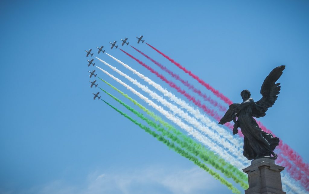 Aviões criando a bandeira italiana através de fumaça
